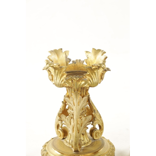 788 - A PAIR OF EARLY 19TH CENTURY GILT ORMOLU FIRE DOGS having rococo style leaf cast mounts on circular ... 