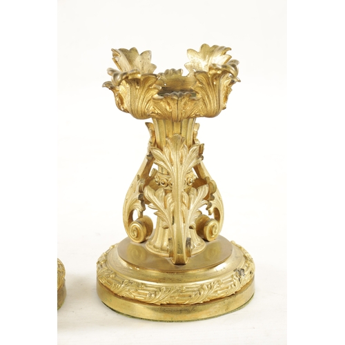 788 - A PAIR OF EARLY 19TH CENTURY GILT ORMOLU FIRE DOGS having rococo style leaf cast mounts on circular ... 