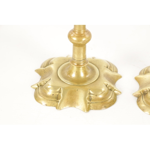 792 - A PAIR OF MID 18TH CENTURY SEAMED CAST BRASS CANDLESTICKS with square petal shaped bases and ringed ... 