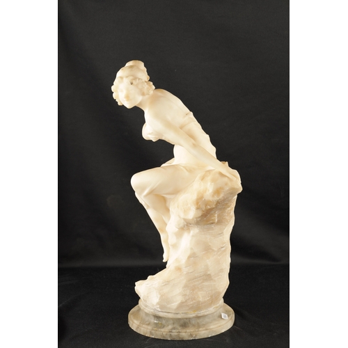 1037 - AN ART NOUVEAU CARVED ALABASTER FIGURE OF A SEMI-NUDE LADY seated on a naturalistic base. (49cm high... 