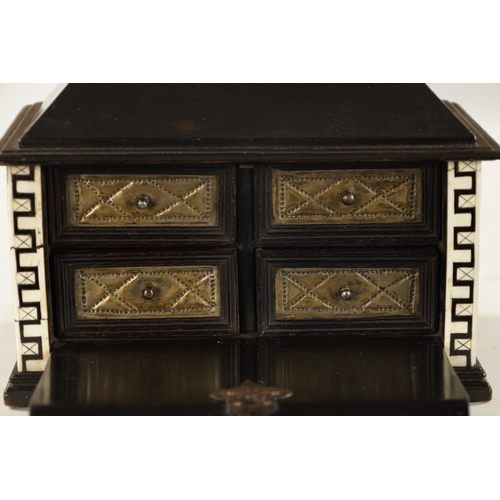 1051 - A 17TH CENTURY GERMAN EBONY AND IVORY MINIATURE TABLE CABINET having foliate inlaid panels, the cham... 