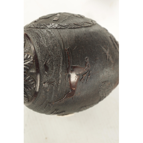 1058 - A FINE 18TH CENTURY CARVED COCONUT POWDER FLASK decorated with a hunting scene, having a flowerhead ... 