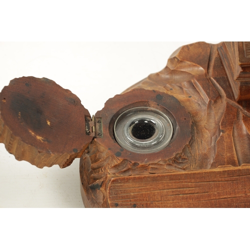 1064 - AN EARLY 20TH CENTURY CARVED FRUITWOOD BLACK FOREST INKWELL having a owl seated on two books raised ... 