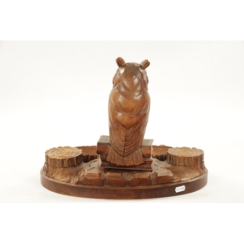 1064 - AN EARLY 20TH CENTURY CARVED FRUITWOOD BLACK FOREST INKWELL having a owl seated on two books raised ... 