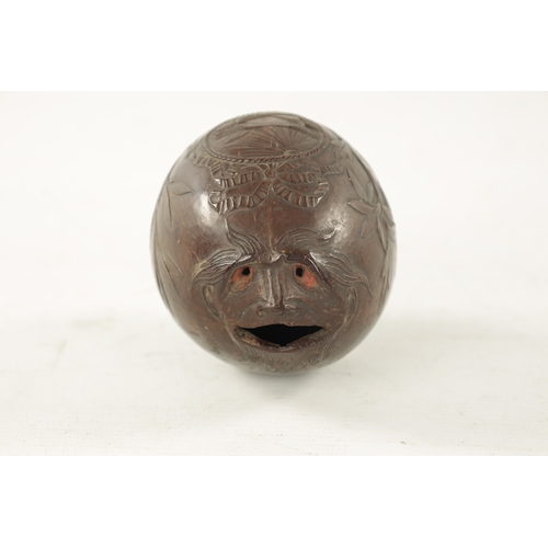 1070 - AN EARLY 19TH CENTURY EASTERN CARVED COCONUT BUGBEAR MONEYBOX with a grotesque face and eyes frontin... 