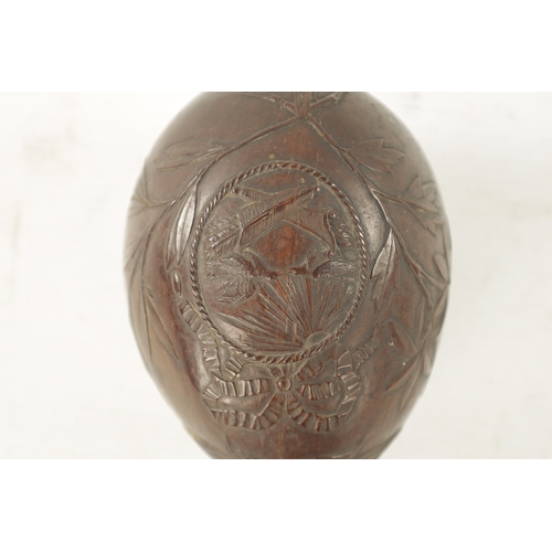 1070 - AN EARLY 19TH CENTURY EASTERN CARVED COCONUT BUGBEAR MONEYBOX with a grotesque face and eyes frontin... 