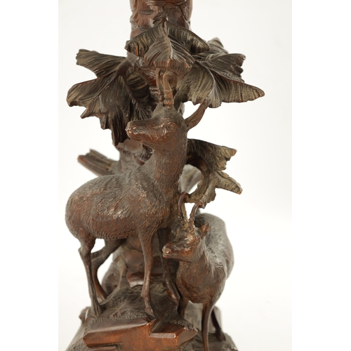 1072 - A LATE 19TH CENTURY CARVED BLACK FOREST EPERGNE CENTREPIECE modelled as two Chamois standing on a ro... 