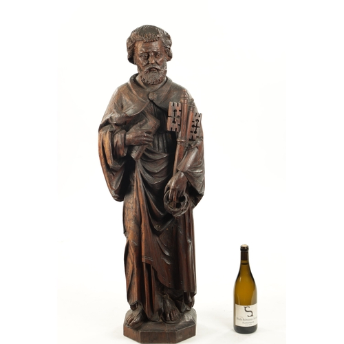 1075 - AN EARLY CARVED FIGURE OF ST. PETER standing holding keys and the bible (103cm high)