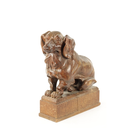 1089 - AN EARLY 20TH CENTURY ‘MOUSEMAN’ STYLE CARVED OAK SCULPTURE modelled as a seated dachund dog raised ... 