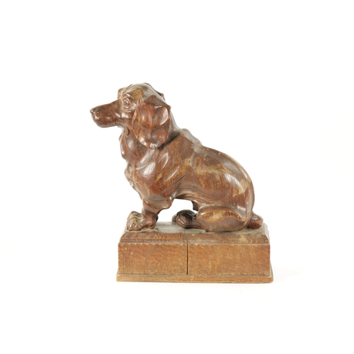 1089 - AN EARLY 20TH CENTURY ‘MOUSEMAN’ STYLE CARVED OAK SCULPTURE modelled as a seated dachund dog raised ... 