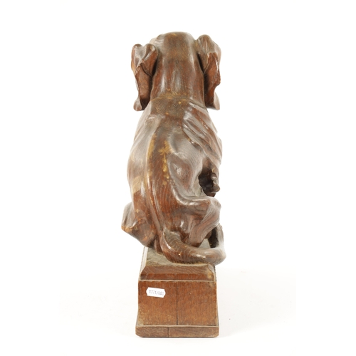 1089 - AN EARLY 20TH CENTURY ‘MOUSEMAN’ STYLE CARVED OAK SCULPTURE modelled as a seated dachund dog raised ... 