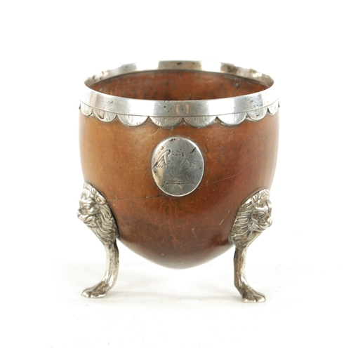 1093 - AN 18TH CENTURY SILVER MOUNTED CARVED COCONUT CUP with lion mask and paw feet, scalloped rim and app... 