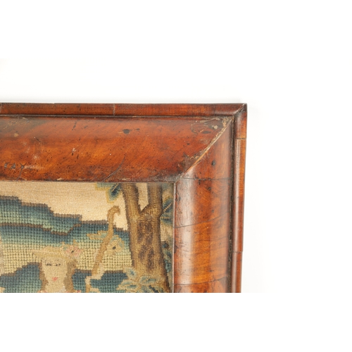 1124 - AN 18TH CENTURY WALNUT CUSHION FRAMED NEEDLEWORK PICTURE depicting a pastoral scene with Shepherd an... 