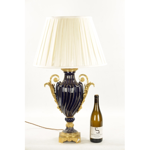 920 - A LATE 19TH CENTURY ORMOLU AND SEVRES PORCELAIN VASE CONVERTED TO A LAMP with gadrooned cobalt blue ... 