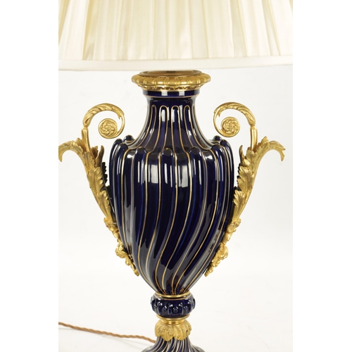 920 - A LATE 19TH CENTURY ORMOLU AND SEVRES PORCELAIN VASE CONVERTED TO A LAMP with gadrooned cobalt blue ... 