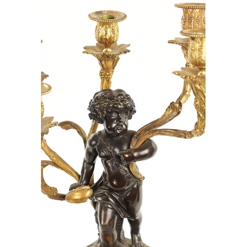 923 - A GOOD PAIR OF ORMOLU AND BRONZE CHERUB FIVE BRANCH CANDELABRA raised on circular rouge marble bases... 