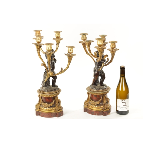 923 - A GOOD PAIR OF ORMOLU AND BRONZE CHERUB FIVE BRANCH CANDELABRA raised on circular rouge marble bases... 