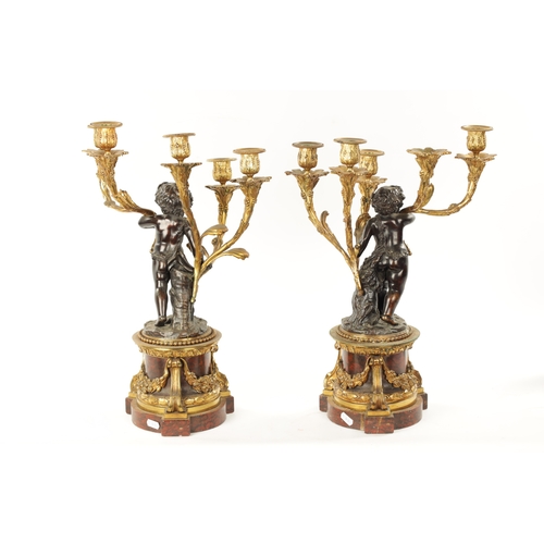 923 - A GOOD PAIR OF ORMOLU AND BRONZE CHERUB FIVE BRANCH CANDELABRA raised on circular rouge marble bases... 