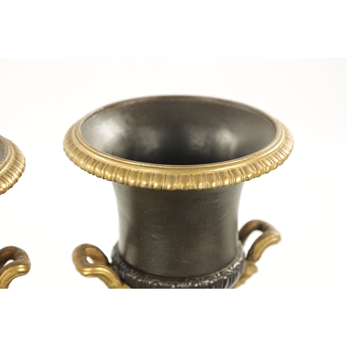 930 - A PAIR OF 19TH CENTURY BRONZED GILT CAST IRON URNS of classical design on square pedestal bases (35c... 