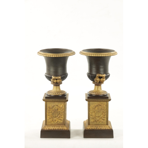 930 - A PAIR OF 19TH CENTURY BRONZED GILT CAST IRON URNS of classical design on square pedestal bases (35c... 