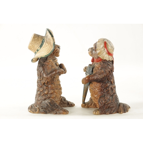 948 - A PAIR OF LATE 19TH CENTURY AUSTRIAN COLD-PAINTED TERRACOTTA MODELS OF DOGS seated with hats and one... 