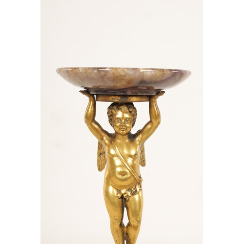 964 - A REGENCY FIGURAL GILT BRONZE, MALACHITE AND BLUE JOHN TAZZA modelled as a gilt bronze winged cherub... 