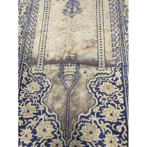 386 - AN ANTIQUE EASTERN PRAYER RUG (108cm wide 60cm deep)