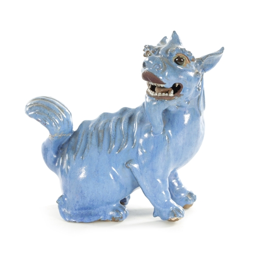 127 - A 19TH CENTURY CHINESE BLUE GLAZED SEATED FOO DOG with painted character marks beneath. (18cm high)