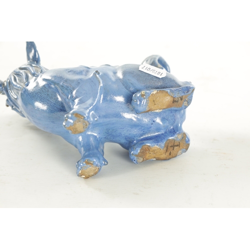 127 - A 19TH CENTURY CHINESE BLUE GLAZED SEATED FOO DOG with painted character marks beneath. (18cm high)