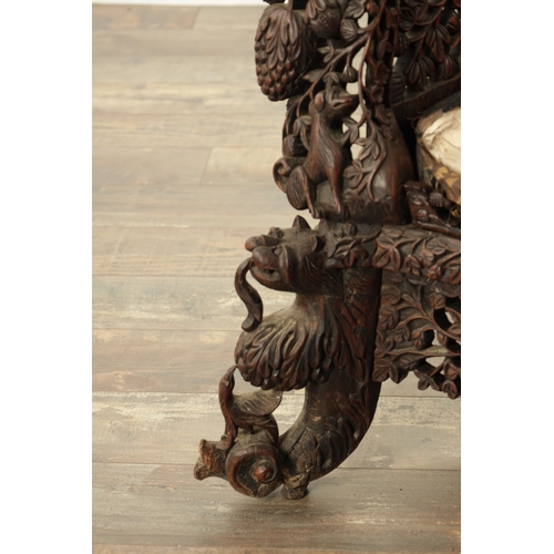 134 - A 19TH CENTURY CARVED HARDWOOD INDIAN ARMCHAIR profusely carved and pierced with leafwork and animal... 