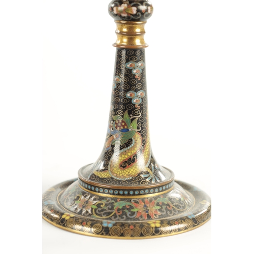 137 - A PAIR OF EARLY 20TH CENTURY CHINESE CLOISONNE CANDLESTICKS decorated with five claw dragons on a bl... 