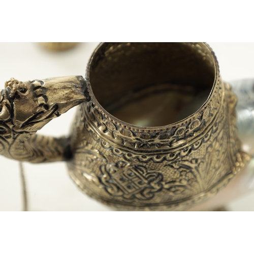 195 - AN EARLY 20TH CENTURY TIBETAN SILVER METAL AND MOTHER OF PEARL SHELL TEAPOT AND JUG with embossed de... 