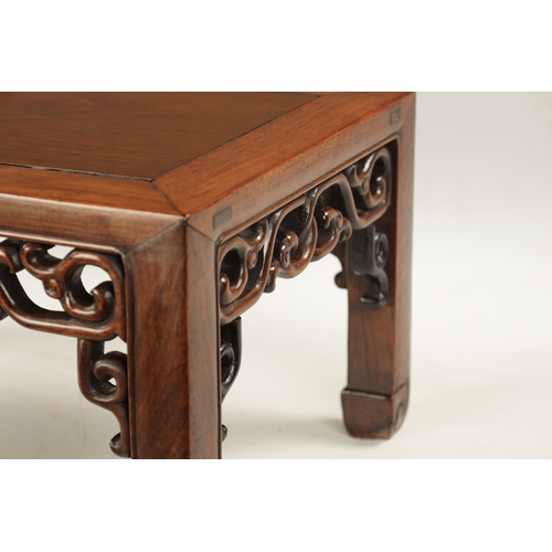 202 - A LATE 19TH CENTURY CHINESE TABLE, POSSIBLY HUANGHUALI with panelled top and pierced carved scrollwo... 