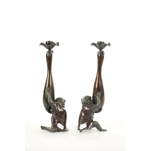 212 - A FINE PAIR OF JAPANESE MEIJI PATINATED BRONZE FIGURAL CANDLESTICKS the plain slender ovoid vase-sha... 