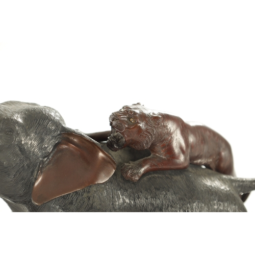 227 - A JAPANESE MEIJI PERIOD BRONZE SCULPTURE OF AN ELEPHANT WITH TIGERS having ivory tusks, signed benea... 