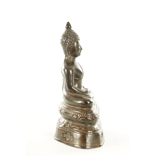 254 - AN EARLY CHINESE PATINATED BRONZE BUDDHA in a seated pose on a leaf work base (24cm high )