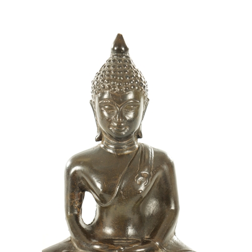 254 - AN EARLY CHINESE PATINATED BRONZE BUDDHA in a seated pose on a leaf work base (24cm high )