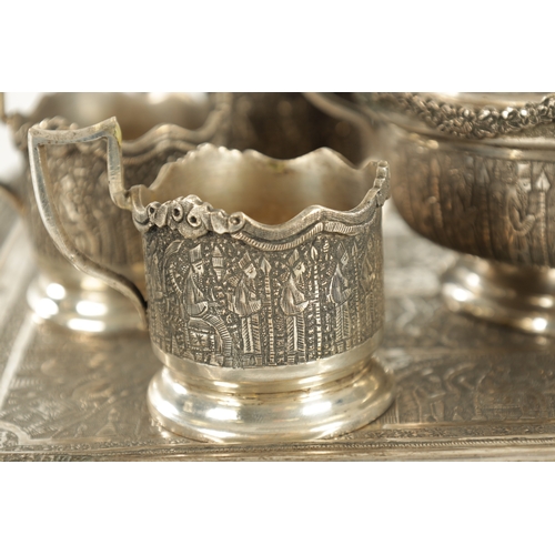 257 - A LATE 19TH CENTURY SILVER METAL PERSIAN COFFEE SET comprising of six cup holders, lidded bowl and t... 