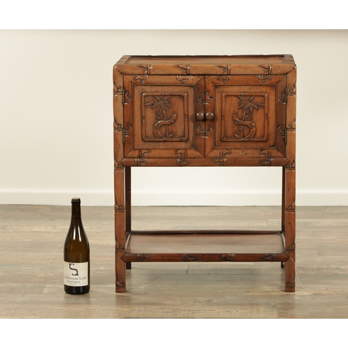 267 - A CHINESE-CARVED HARDWOOD BEDSIDE CABINET with faux bamboo carved frame and fielded panelled hinged ... 