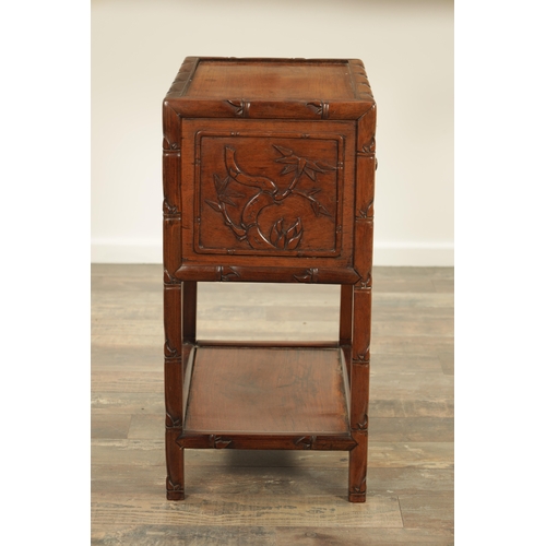 267 - A CHINESE-CARVED HARDWOOD BEDSIDE CABINET with faux bamboo carved frame and fielded panelled hinged ... 