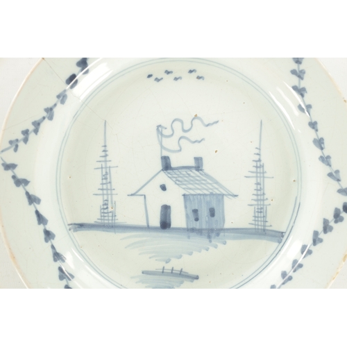 28 - AN 18TH CENTURY BLUE AND WHITE DELFT SHALLOW DISH with cottage landscape decoration (23cm diameter)