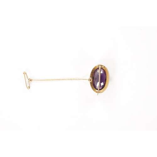 286 - A GOLD METAL AMETHYST AND PEARL BROOCH With large oval cut stone with a hinged pin and safety chain.... 