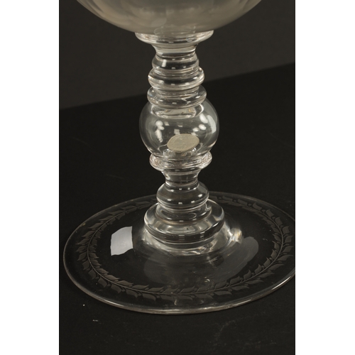 3 - AN OVERSIZED LATE 19TH CENTURY ENGRAVED GLASS COIN GOBLET the body having floral decoration and insc... 