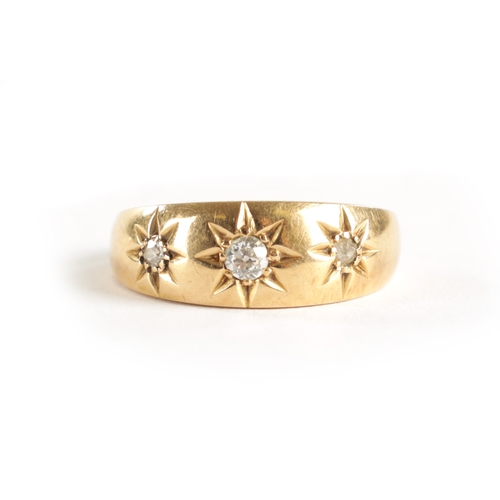 305 - AN 18CT GOLD THREE STONE DIAMOND GIPSY RING with brilliant cut diamonds in a star-engraved setting, ... 