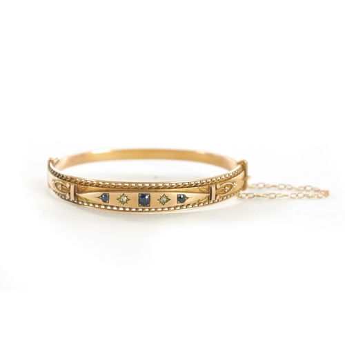 309 - A LADIES VINTAGE 9CT GOLD DIAMOND AND SAPPHIRE BANGLE With pierced and filigree decoration set with ... 