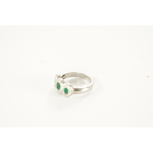 310 - A LADIES 18CT WHITE GOLD THREE STONE EMERALD AND DIAMOND RINGE with a continuous triple loop diamond... 