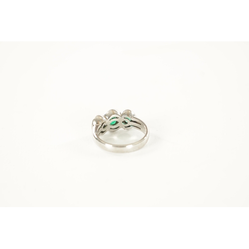 310 - A LADIES 18CT WHITE GOLD THREE STONE EMERALD AND DIAMOND RINGE with a continuous triple loop diamond... 