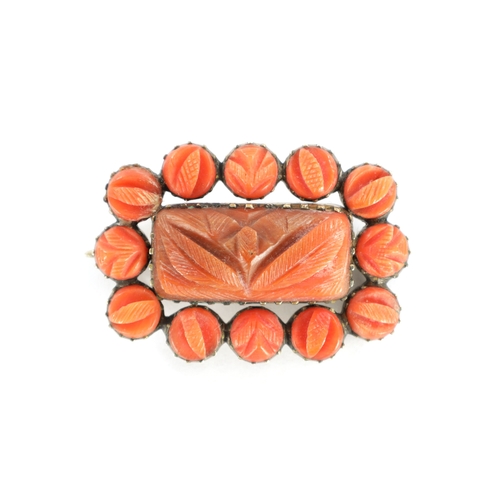 318 - AN ANTIQUE GOLD AND CARVED CORAL BROOCH With glazed platted hair panel on the reverse. (34mm wide)