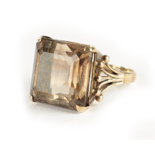 319 - A LARGE 9CT GOLD SMOKEY QUARTZ RING The square cut stone mounted in a pierced claw setting, total we... 