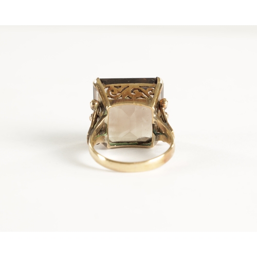 319 - A LARGE 9CT GOLD SMOKEY QUARTZ RING The square cut stone mounted in a pierced claw setting, total we... 